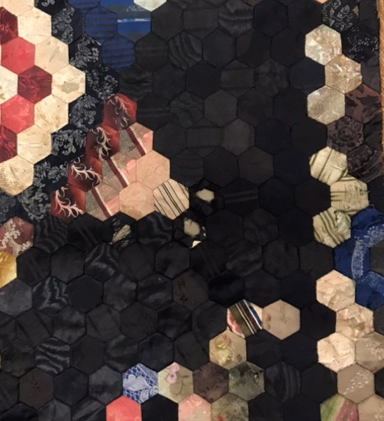 An image of various coloured fabrics in hexagons.