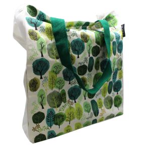 An image of a white tote bag with a patter of various shaped trees in shades of green. The handle is a bright emerald.