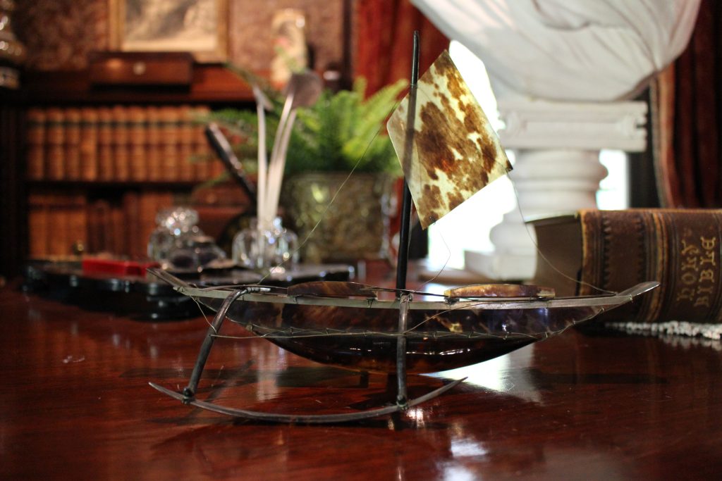 A brown boat on a wooden table.