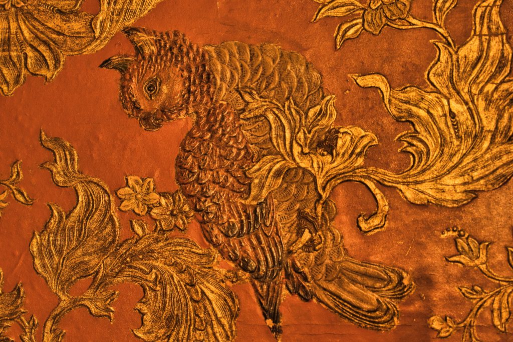 Textured gold and orange wallpaper with bird motifs done in a Japanese artstyle