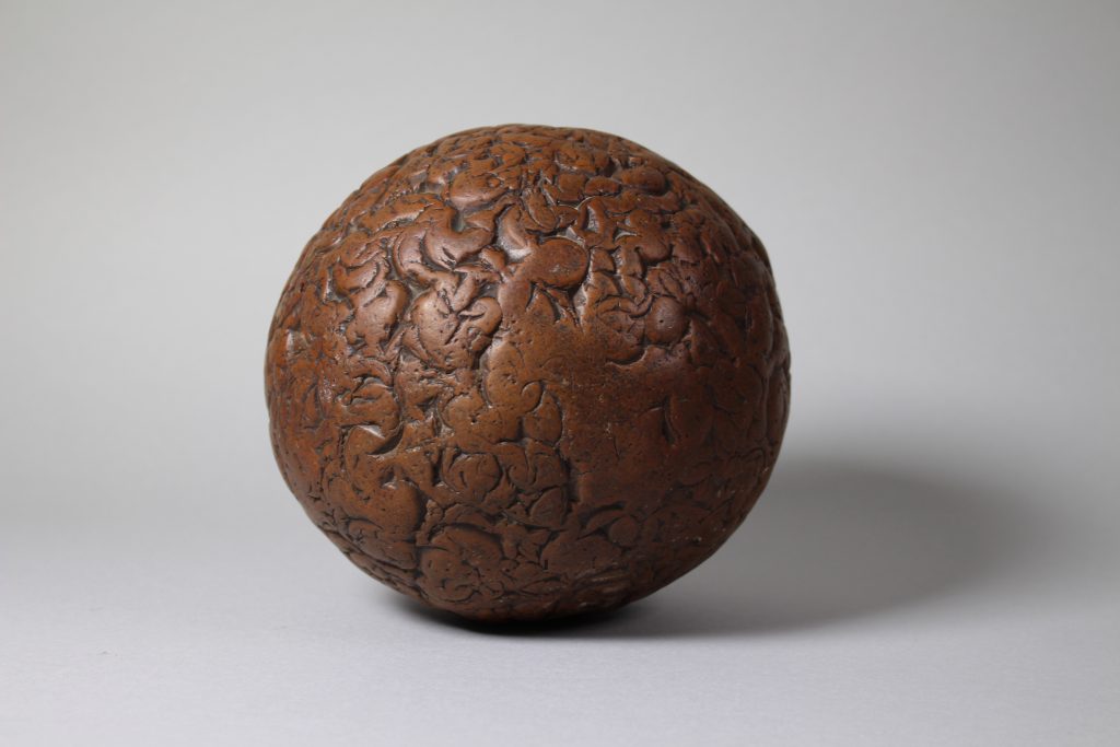 An image of a brown sphere with lines all over.