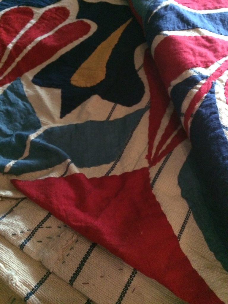 An image of folded up fabric. It has red, blue, green, and white details.