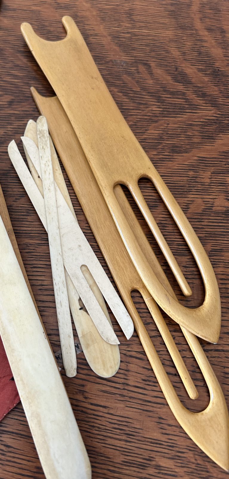 An image of long wooden tools with oval holes in the centre.