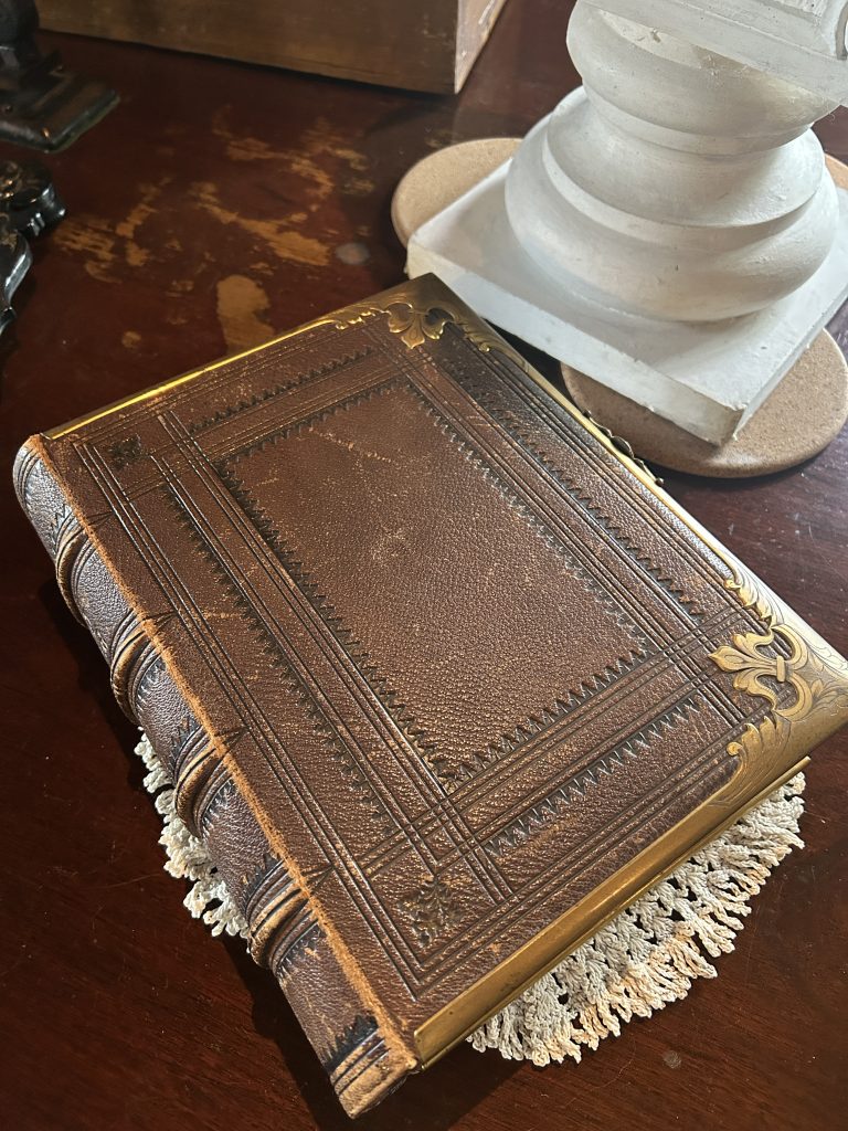 A brown leather bound book with gold details on the cover.
