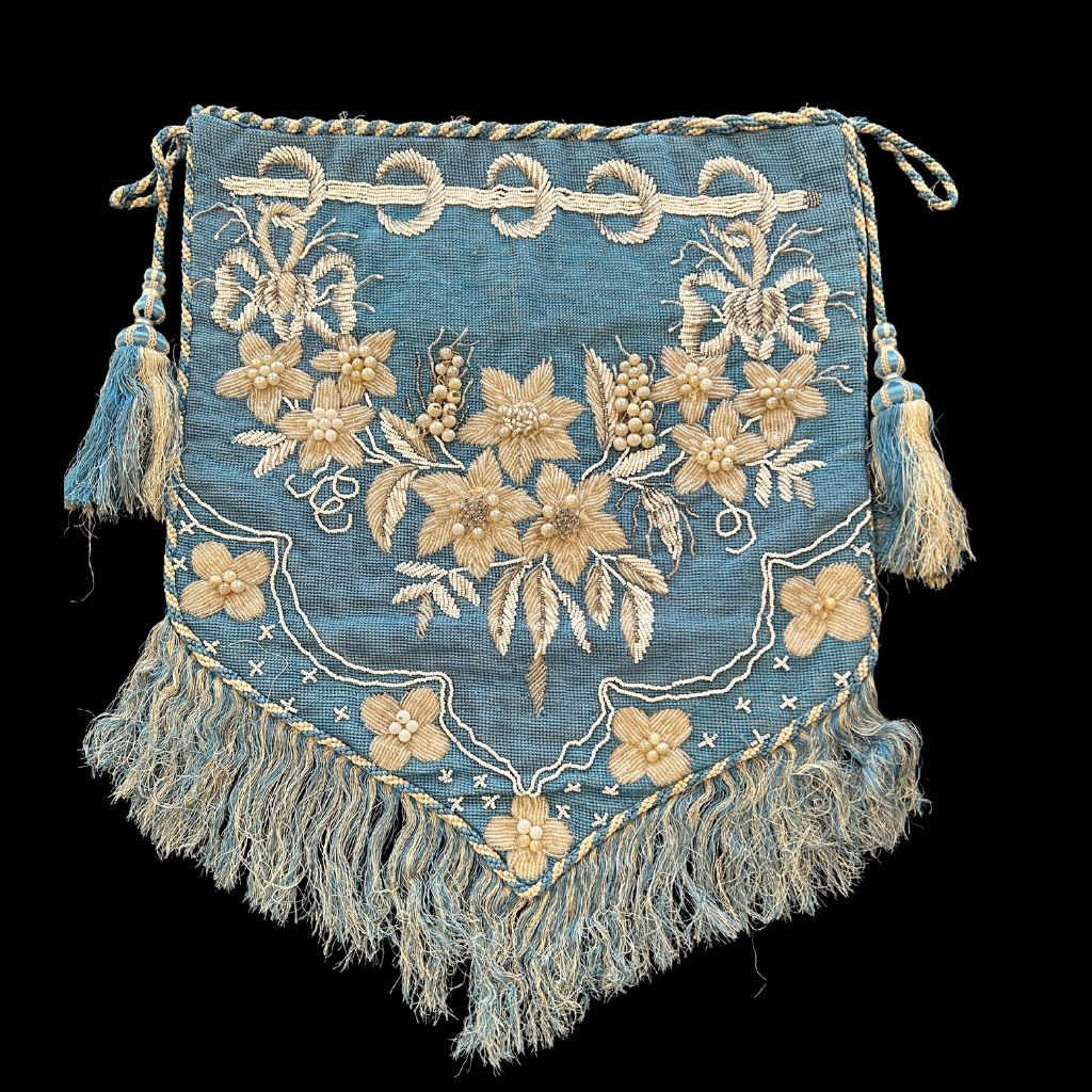 A banner with a rectangular fringed edge. The banner is blue with white and cream details.