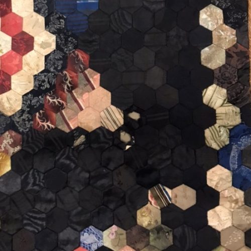 An image of various coloured fabrics in hexagons.